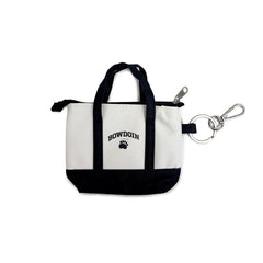 A small zippered tote bag with a white canvas body, black handles and bottom trim, and a black 'BOWDOIN' and paw print logo on the front. It is shown with a silver clip on a plain white background.