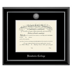 Diploma frame with glossy black moulding with silver fillet and black and silver matting. Silver sun seal medallion set into the mat on top of the diploma, BOWDOIN COLLEGE embossed in silver below.