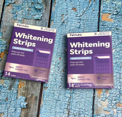 Two packages of Feimuko Whitening Strips on a textured blue and brown surface