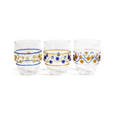 Three Festa Tumblers by Zodax in green, amber, and blue tones, each adorned with wavy lines and dots, are displayed side by side on a white background. Crafted from soda lime glass, this vibrant stemless drinkware adds flair to any setting.