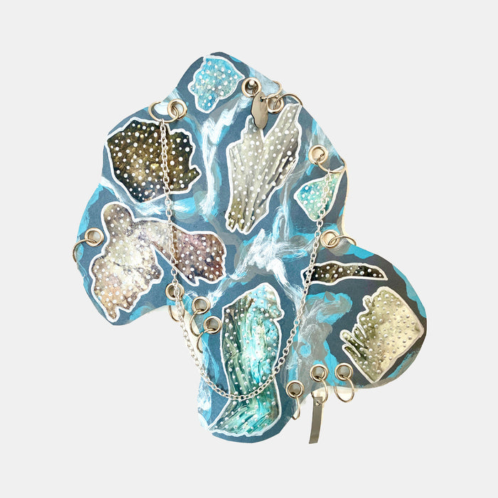 The artwork 'Noumenon' by Sunny Chapman features abstract organic shapes in turquoise, silver, and gold tones floating on a vibrant blue background. The acrylic painting showcases crystalline formations with textured, metallic-like surfaces interconnected by delicate gold dots and flowing lines, creating a dynamic aquatic-inspired composition on paper.