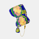 The artwork 'Remembrance 1' by Sunny Chapman features an abstract composition with fluid organic shapes in vibrant royal blue and emerald green borders. Golden-peach central forms are adorned with dotted white accents and purple highlights. A small chartreuse pendant element hangs from a delicate chain, creating a jewelry-like aesthetic in acrylic on paper.