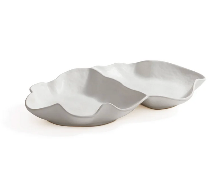 The Zodax Alto Two Section Ceramic Serving Bowl features a modern, sculptural matte white design with two connected, irregular compartments, resembling abstract leaf or shell forms.