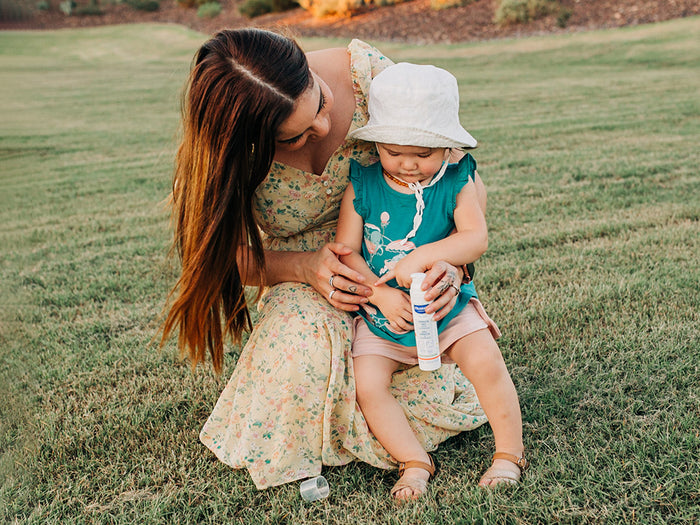 Mustela USA | Baby and mom holding Arnica Gel in a grassy field