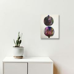 The artwork 'c1' by Arielle Stein features two circular pomegranate forms in watercolor and acrylic ink. The spherical shapes showcase swirling deep purples, magentas, and navy blues against a crisp white background, creating an ethereal, abstract interpretation of the fruit's natural form. The fluid, organic style captures the essence of botanical art with a contemporary twist.