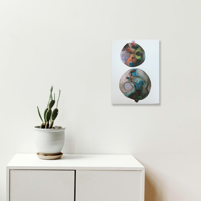 The artwork 'c2' by Arielle Stein features two circular forms in fluid watercolor and acrylic ink. The top circle displays swirling oranges and deep purples, while the larger bottom circle showcases flowing turquoise and earth tones creating a mesmerizing marble-like effect against a white paper background. The abstract composition evokes planetary or celestial imagery. By Arielle Stein.