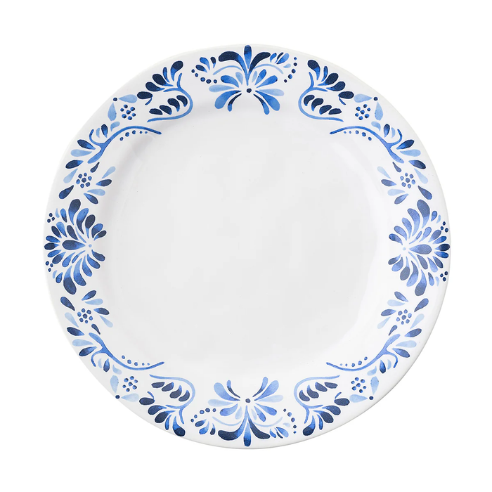 The Juliska Iberian Dinnerware features a round white dinner plate with a cobalt blue floral rim pattern inspired by Iberian Journey tiles; the center is plain and unadorned.