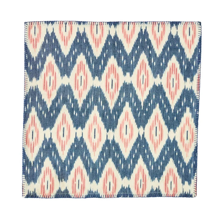The Ikat Napkin - Set/4 by Juliska features a geometric blue, white, and blush pattern with diamonds and zigzags—perfect for bringing an island-inspired touch to your table.