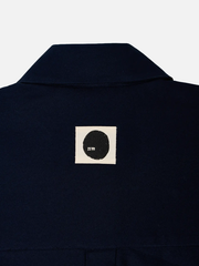 SHOPI GO Meguro Regular Shirt - Navy – arka yaka görünümü, beyaz yama üzerinde siyah daire logo