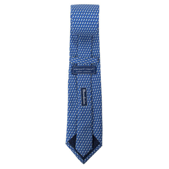 Back view of a blue silk tie with an all-over imprint of the Hyde Plaza polar bear showing Vineyard Vines label and Bowdoin wordmark.