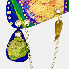 The artwork 'Remembrance 1' by Sunny Chapman features vibrant curved shapes with deep cobalt blue borders adorned with cream-colored dots. The composition includes bright green elements and textured golden-yellow areas, connected by delicate gold chain accents. The abstract acrylic painting on paper showcases a dynamic interplay of organic forms and metallic details.
