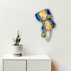 The artwork 'Remembrance 1' by Sunny Chapman features an abstract organic shape in vibrant royal blue and emerald green borders, adorned with white dotted patterns. The central areas showcase peachy-gold iridescent sections, creating a luminous effect. The 12x16 inch acrylic painting appears to float against a white background, displayed above a modern cabinet with a potted cactus.
