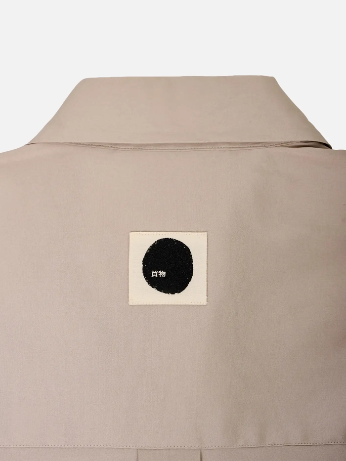 shopi go Sumida Boxy Shirt - Beige – arka görünüm, bej kumaş ve siyah daireli etiket
